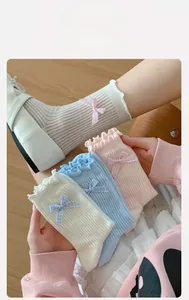 Detail of ruffle cuffs and plaid bow accents on breathable cotton ribbed mid-calf socks