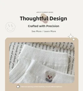 Close-up of cute bear embroidery on white ribbed cotton ankle socks with soft cuffs