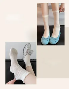 Detail of white mesh lace socks with floral patterns and ruffled cuffs for women