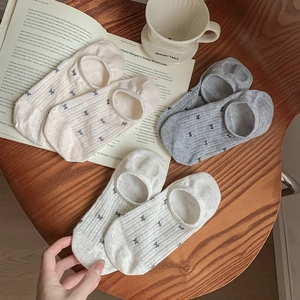 Three pairs of mesh bow-tie low cut invisible socks on a rustic wooden table setup