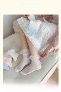 Detailaufnahme weißer Socken mit Spitzenbesatz und eleganten Schleifenakzenten