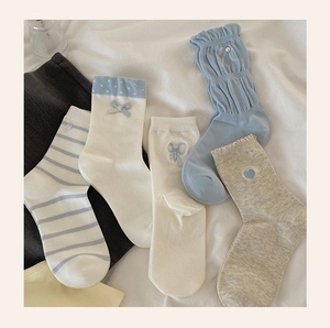 Detail of five pairs of blue and white cotton crew socks with bows and heart patterns