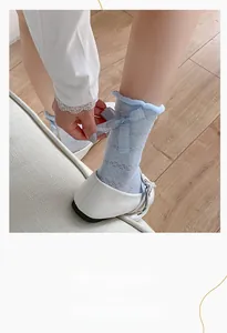 Detail of light blue mesh crew sock with elegant knit pattern and a delicate ribbon bow