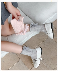 Detail of girls mesh knit socks with bow accent in soft grey and pink candy colors
