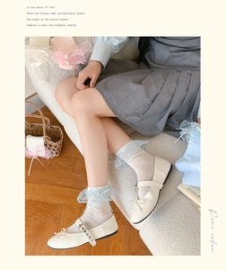 Detail von weißen Lolita-Socken mit hellblauer Spitze und Schleife auf Mary Jane Schuhen