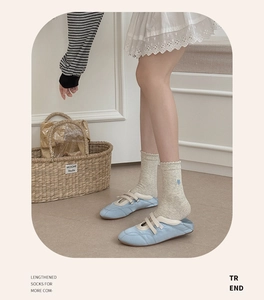 Detail of blue heart embroidery on mid-calf socks with frilled edges and Mary Jane shoes