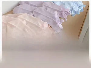 Detail of breathable hollow-out cotton socks with silk bow in pink, purple, and blue colors