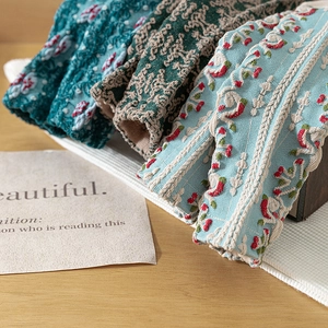 Vintage floral knit socks with 3D embossed pattern and beige lace trim on wooden desk