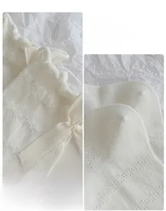 Detail showing white hollow mesh knit sock with a delicate ribbon bow on the elastic cuff