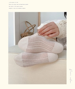 Détail de chaussettes en dentelle beige avec motif en maille ajourée verticale