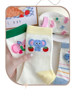 Detail of cute elephant socks in white cotton with colorful heels and fruit patterns