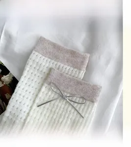 Macro detail of breathable mesh knit socks with bow decor and high elastic cuff