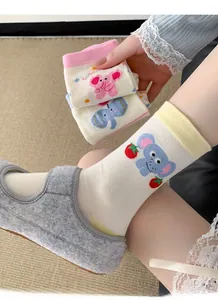 Close-up of white cotton socks with cute cartoon elephant patterns and pink toe details