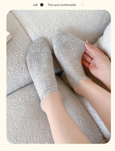 Gros plan de chaussettes en maille gris clair avec motifs ajourés pour l'été