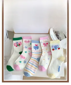 Detail display of five cream cotton socks with colorful cartoon elephant patterns and stripes
