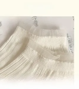 Détail de chaussettes en dentelle blanche avec revers élastiques côtelés et texture douce