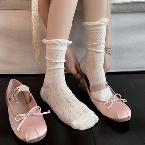 White frilly lace crew socks with hollow patterns paired with pink satin ballet flats