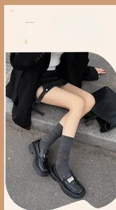 Détails de jambières en coton gris foncé avec lofer noirs dans un décor extérieur