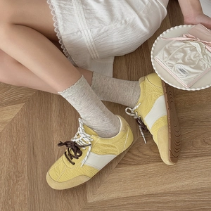 Lace ruffle socks paired with patchwork pleated casual shoes on warm wood floor