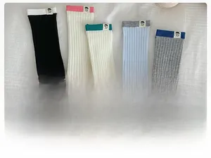 Flat lay of ribbed cotton mid-calf socks in diverse colors with minimalist fabric labels