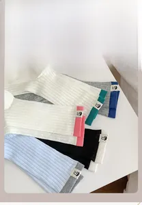 Detailed display of colorful ribbed mid-calf socks with cute fabric label patches