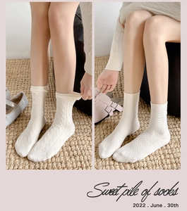 Detailansicht der cremefarbenen Stricksocken mit Rautenmuster und Rippstrick
