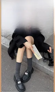 Détail de chaussettes côtelées gris foncé avec mocassins plateforme en cuir noir à boucle