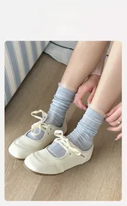 Detailed view of light blue striped mesh socks with lace trim and Mary Jane shoes