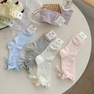 Pastel mesh knit crew socks with bow cuff detail in candy colors set on display