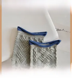 Détails de chaussettes en tricot gris avec revers bleu et motifs en relief