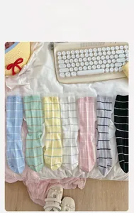 Detail of striped cotton socks with delicate lace trim edges in various pastel colors