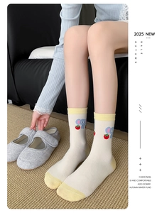 Detail of white cotton sock with elephant and strawberry pattern and yellow accents