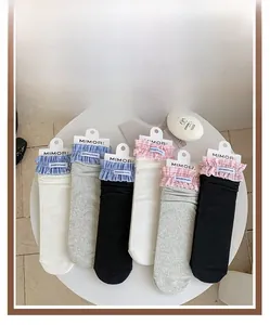 Dettaglio di calze in maglia con volant a quadri colorati e etichette di marca in tre colori