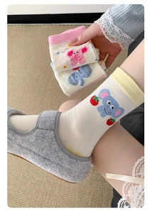 Detail of cute elephant pattern and strawberry embroidery on knit cotton socks