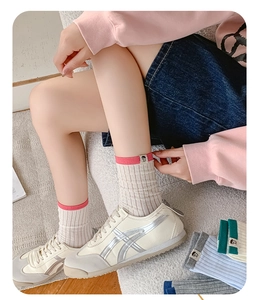 Detail of ribbed cotton socks featuring colorful contrast edges and small cartoon patches