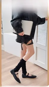 Gros plan de jambières grises avec veste en cuir noir et short en jean pour femmes