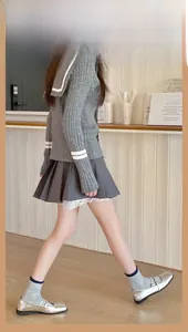 Détail de chaussettes mi-mollet bleu-gris avec jupe plissée et chaussures Mary Jane argent