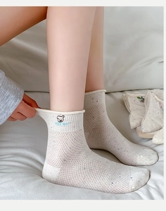 Detailansicht der atmungsaktiven Netzsocken mit Bärenstickerei und bunten Punkten