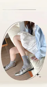 Detail of grey crew socks with blue ribbon bow and ruffled cuffs with Mary Jane shoes