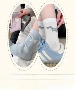 Detail of cute Westie dog socks with ribbon bows in blue, pink, gray and beige
