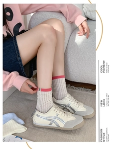 Detail of college style crew socks with vertical stripes worn with casual retro sneakers