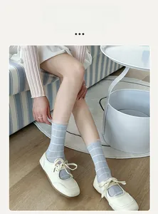 Detail of light blue striped crew socks with lace trim paired with Mary Jane flats