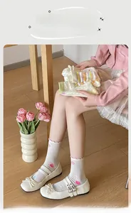 Close-up of sheer mesh socks featuring pink polka dots and ruffled edge design