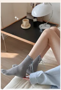 Detail of sweet Lolita style crew socks with light blue ribbons and lace trim finish