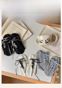 Three pairs of ballet-style socks with silk ribbon bows and lace ties on a table