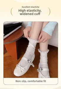 Detail of white mid-calf socks with delicate lace trim and sweet bow embellishments