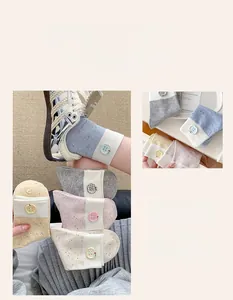 Detail of macaron mid-calf socks with colorful speckled texture and apple button decor