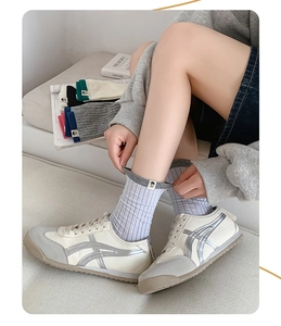 Close-up of ribbed cotton mid-calf socks with cloth tag paired with vintage sneakers