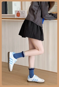 Détail de chaussettes mi-mollet bleues avec motif en relief et revers gris multicouche