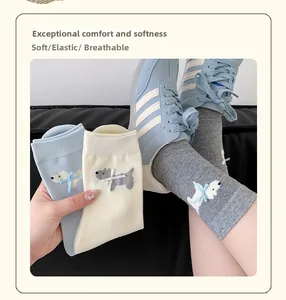Detailed close-up of cute cartoon puppy socks with bows in blue, beige, and grey colors